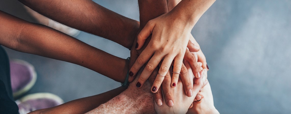 Multiple sets of hands stacked on top of one another